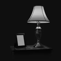 A photo frame on a table next to a lamp